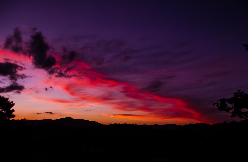 silhouette of trees and mountains during sunset