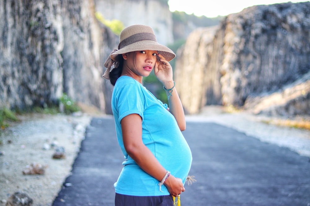 Femme en haut bleu portant un chapeau