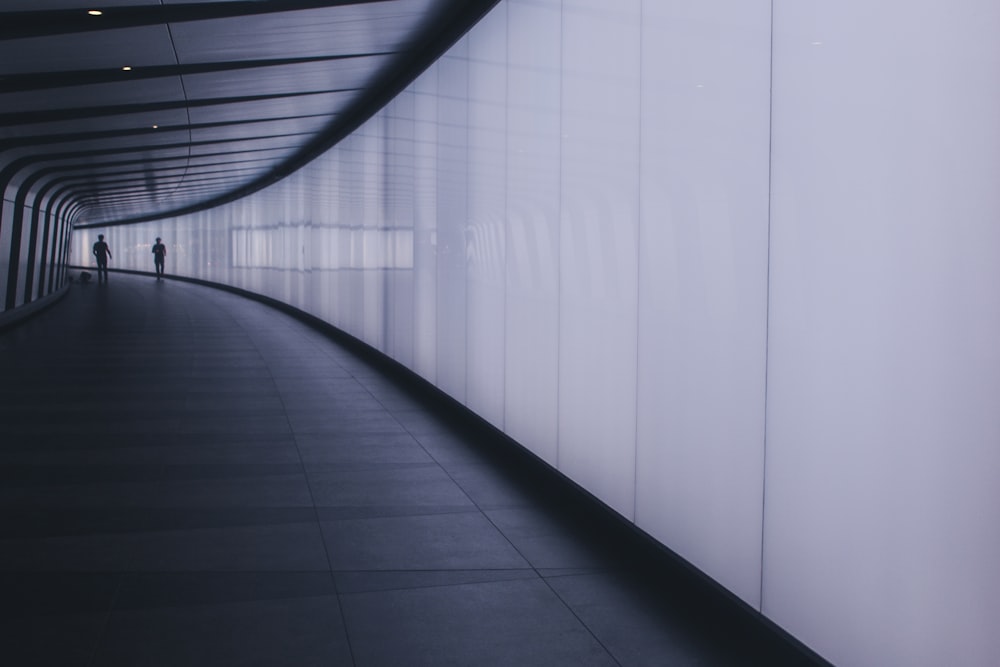 two people walking in hallway