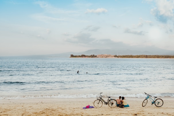 A tranquil beach scene with bicycles on the sand.