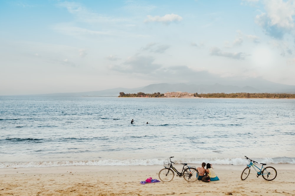 two people sitting on seashore during daytime