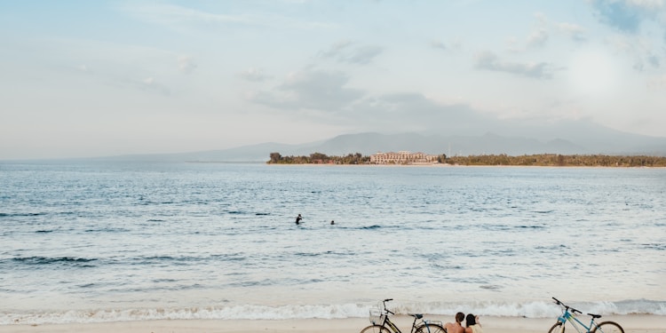 two people sitting on seashore during daytime
