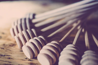 Close-up of fresh organic honey jars with natural wooden honey dippers on rustic wooden table