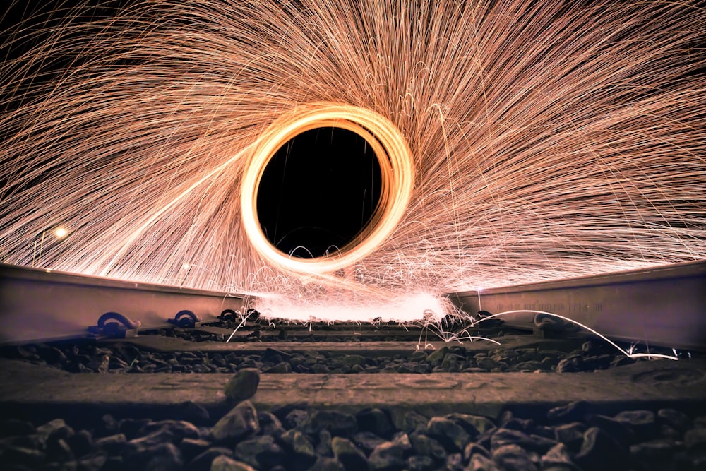 steel wool photo of person fire dancing on rail