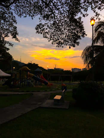 Evening shot of a residential society playground with illuminated play equipment.