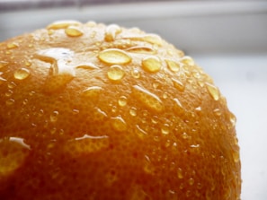 Close-up of fresh orange slices with droplets of juice glistening in natural light.