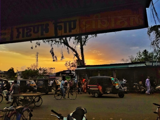 A candid shot of thokar filming a vibrant street scene during golden hour.
