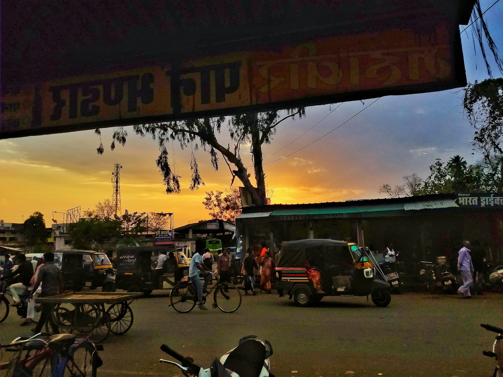 A bustling street scene in India at sunset, vibrant colors blending with motion blur, capturing the rhythm and life of everyday moments through a cinematic lens.