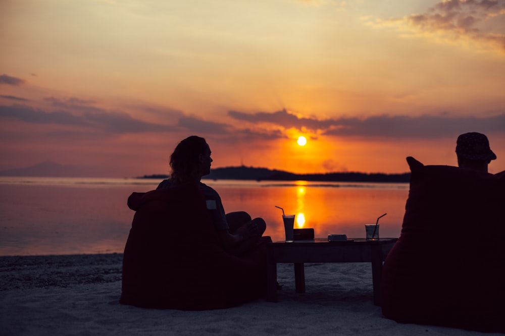 silhouette of person sitting on chair during sunset