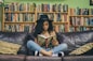woman reading a book while sitting on black leather 3-seat couch
