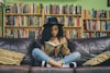 woman reading a book while sitting on black leather 3-seat couch