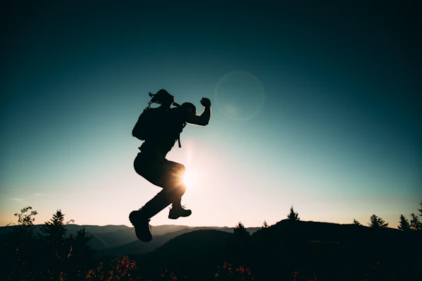 A male influencer capturing travel content against a dramatic sunset backdrop, embodying luxury and adventure.