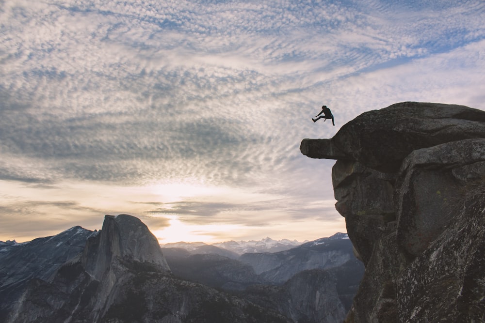 person jumping on edge of cliff