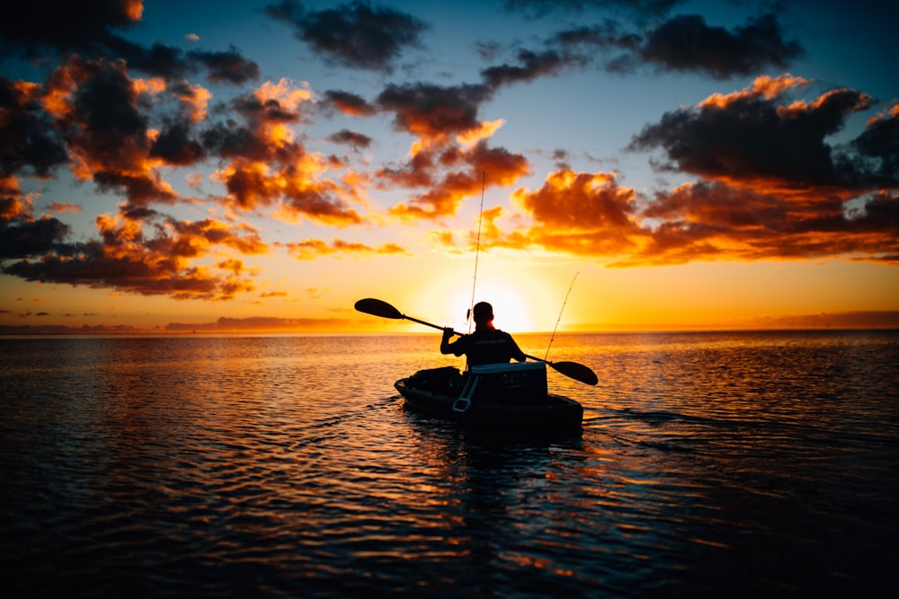 silhouette of person using boat