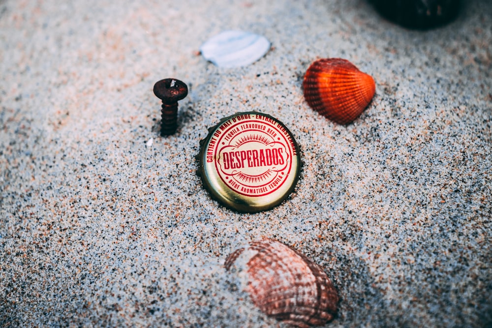 bottle crown and seashell on sands