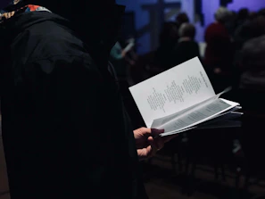 An author reading from their manuscript at a small community event