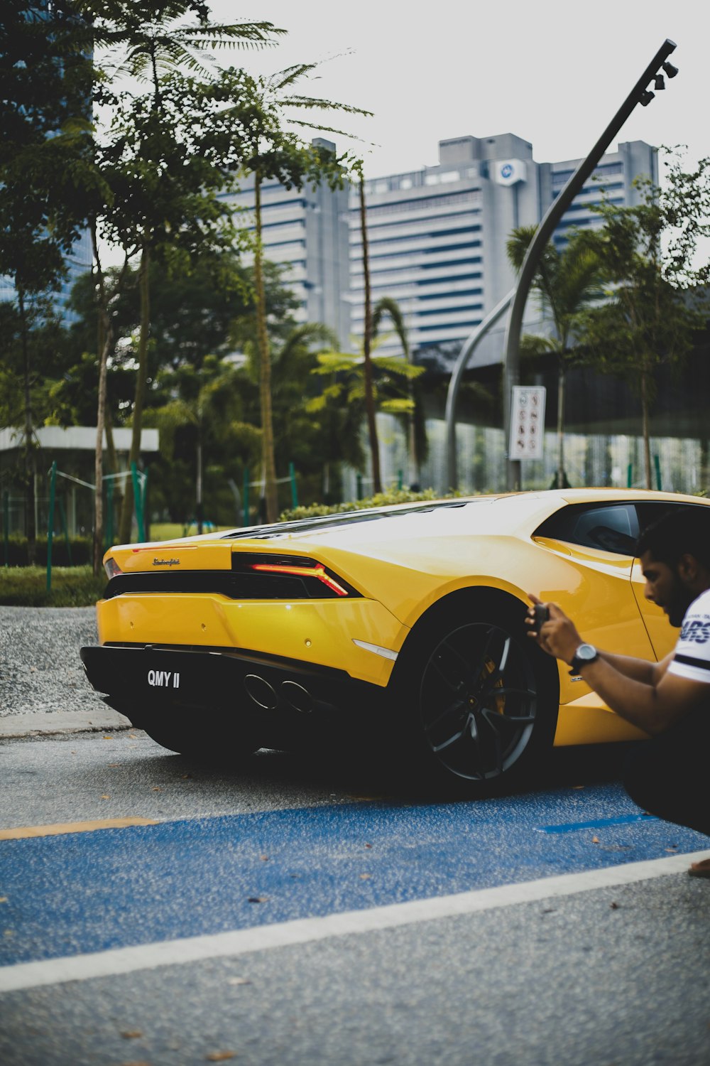 person holding camera near yellow car