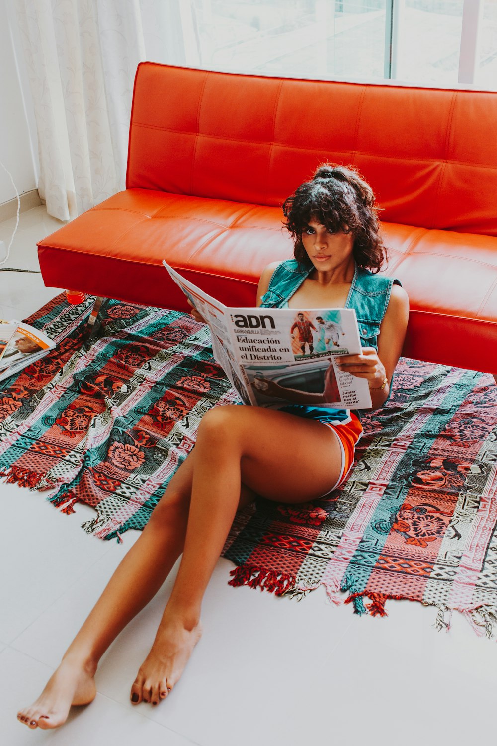 Frau sitzt tagsüber auf dem Boden und liest Zeitung