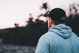 man wearing blue hoodie and black hat