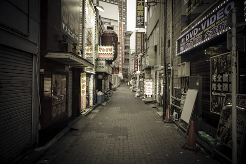 A desolate urban street with flickering neon signs and scattered debris.