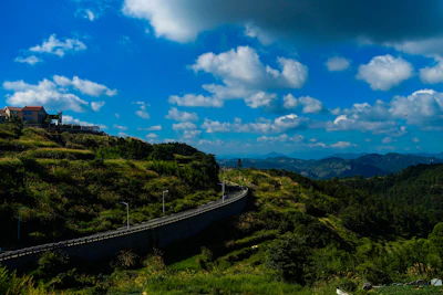 A panoramic view of a winding road cutting through rolling hills captured on a scenic drive.