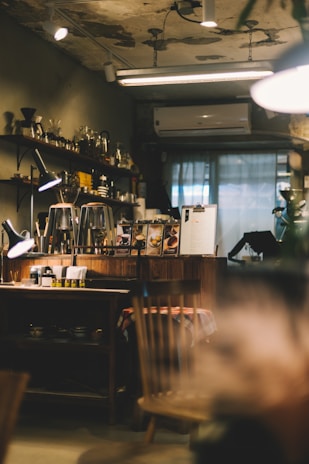Warm interior of Fiqasi cafe with rustic wooden tables and soft lighting highlighting a steaming cup of coffee.