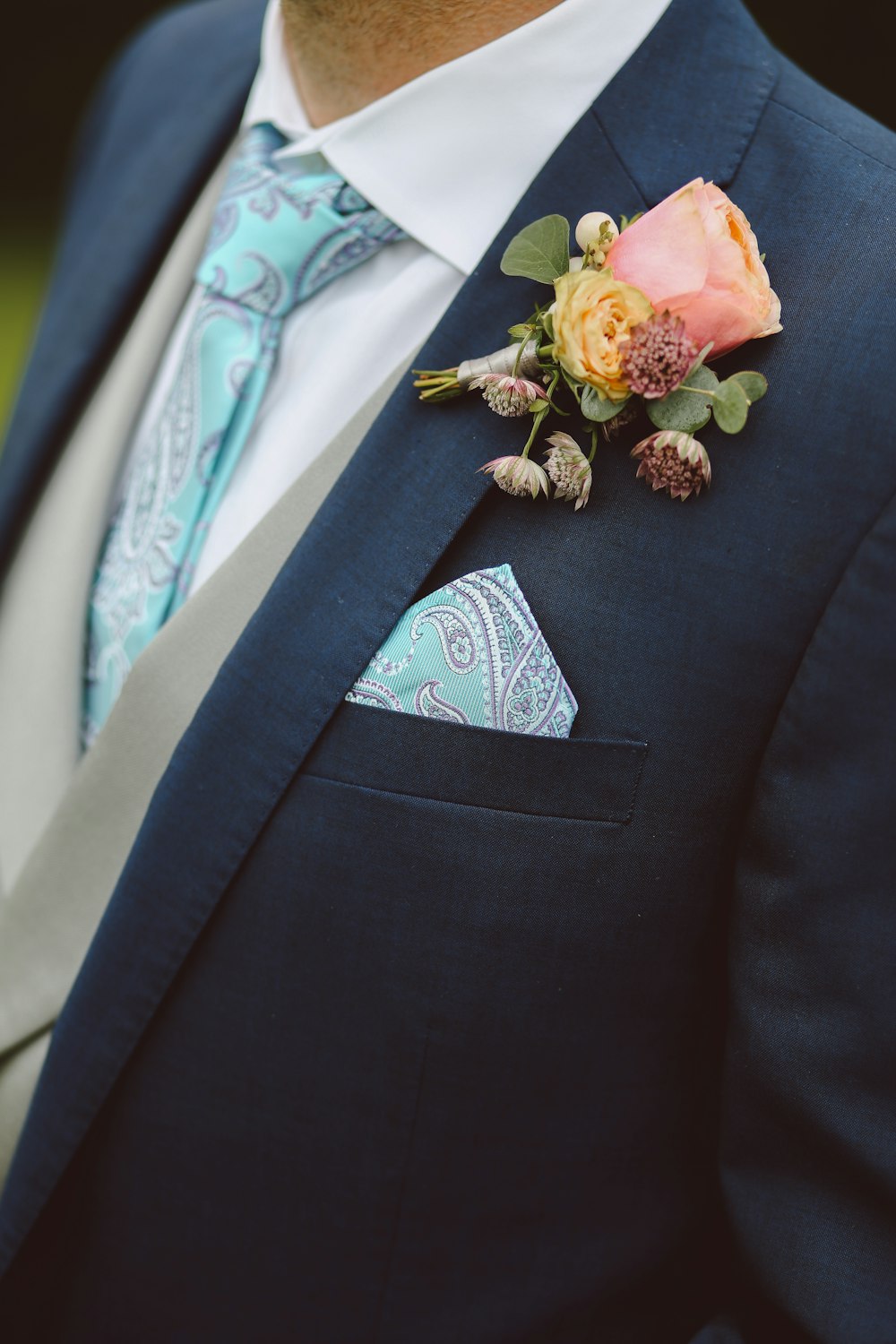 man in black formal coat and teal necktie