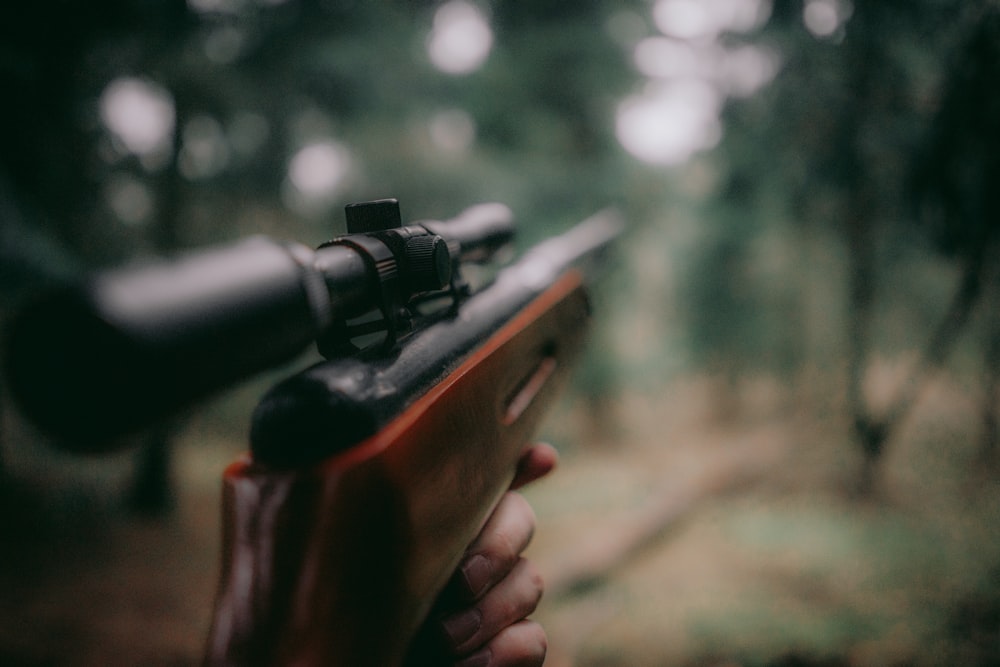 Fotografía de enfoque selectivo de rifle de caza marrón