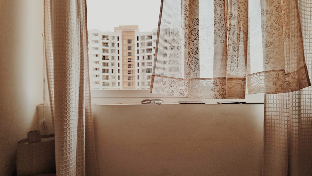 white and brown building see through window during daytime