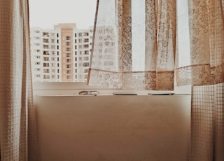 white and brown building see through window during daytime