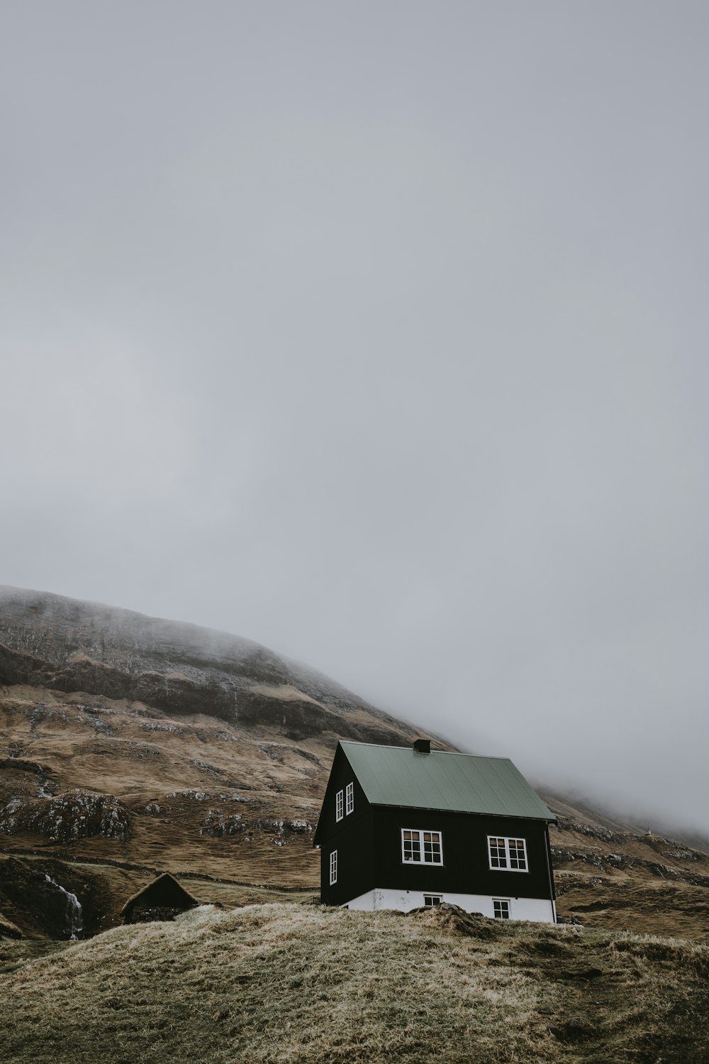 black and white wooden house on top of hill