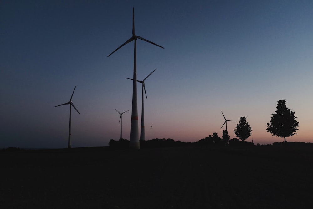 wind turbines silhouette under blue and white sky