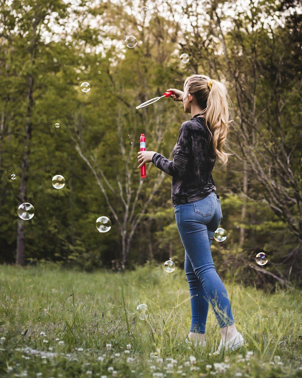 woman holding bobble rack surrounded by grass