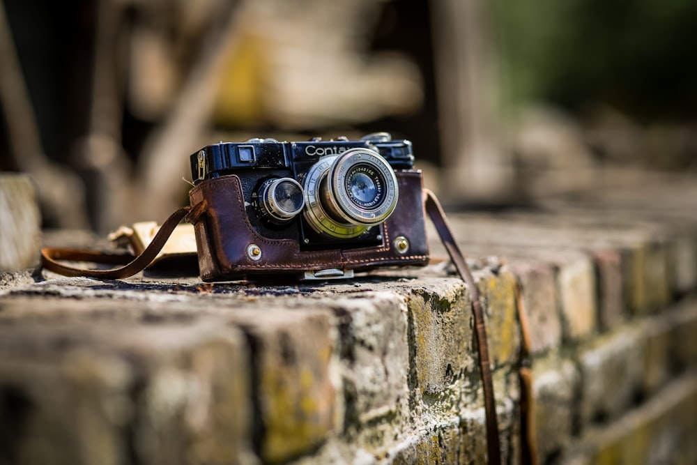 black SLR camera on brown brick surface