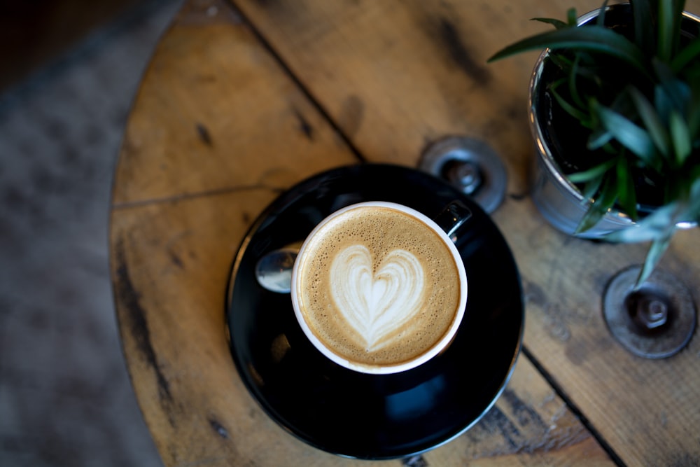 cup with heart capuccino on table