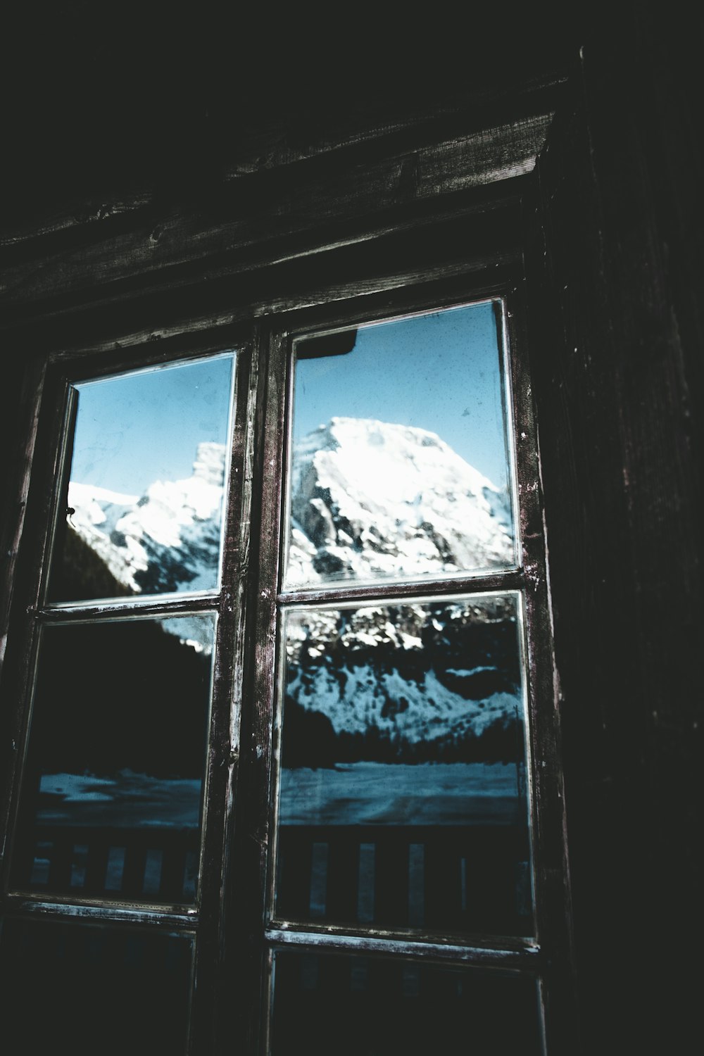 a mountain seen through a window in a dark room