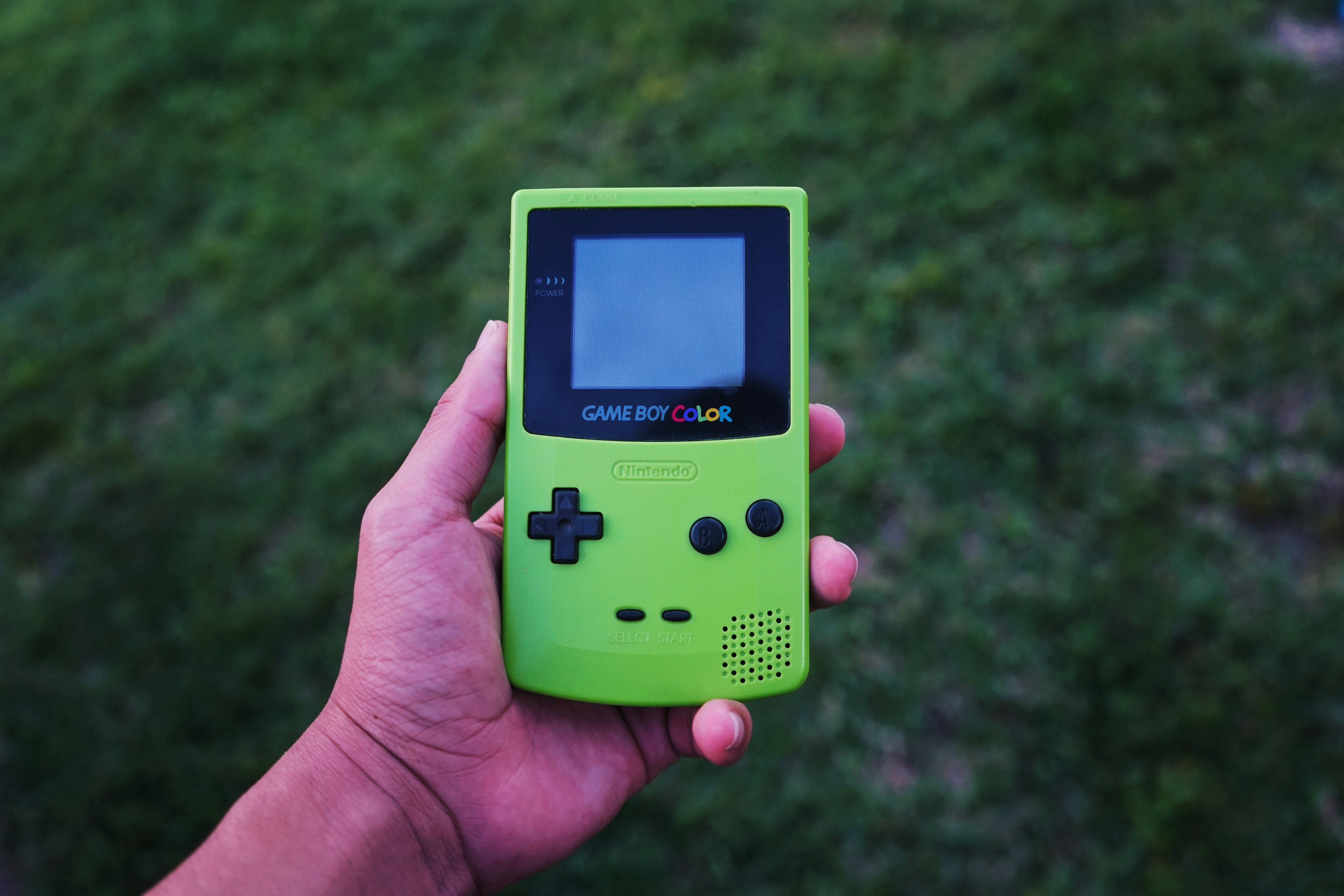 person holding a green Gameboy color console