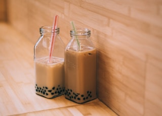 two clear glass jars with straws