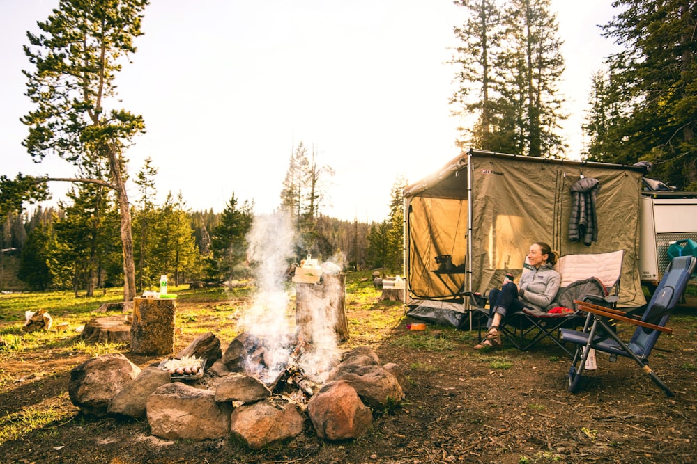 donna che si siede sulla sedia vicino alla tenda