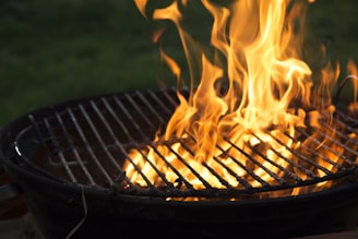 A sturdy charcoal grill with flames rising, perfect for outdoor cooking at a family gathering.