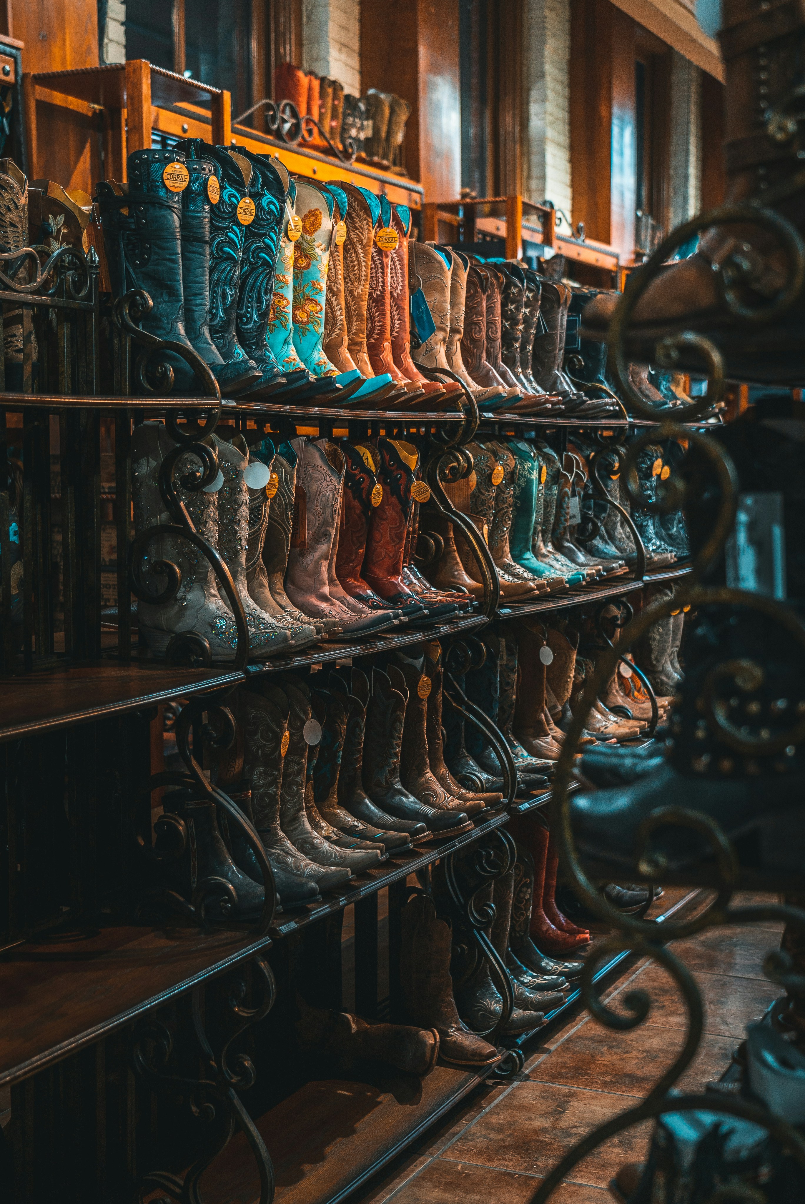 brown and blue leather cowboy boots on rack in texas