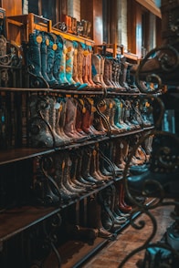 brown and blue leather cowboy boots on rack