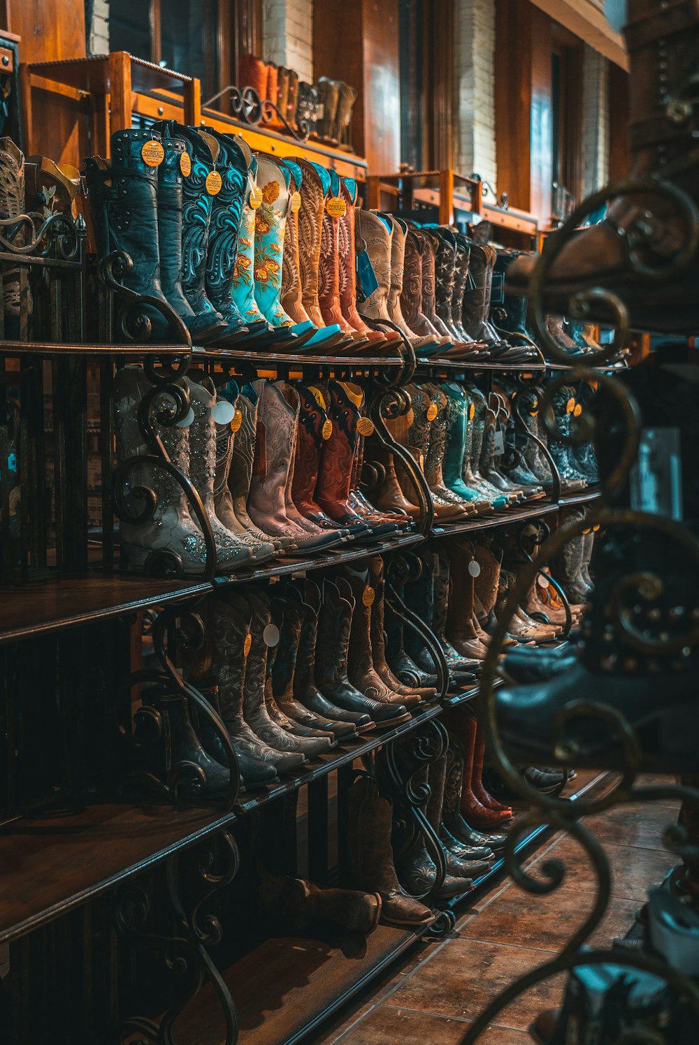 brown and blue leather cowboy boots on rack