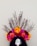 A vibrant floral headdress with a variety of colorful flowers such as orange, yellow, pink, and red, arranged in an arc. Branches extend upward from the arrangement, adding a natural, organic element. The headdress appears to be worn on a mannequin or head form with dark, long hair.