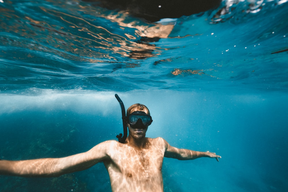 homme sous l’eau en regardant la caméra