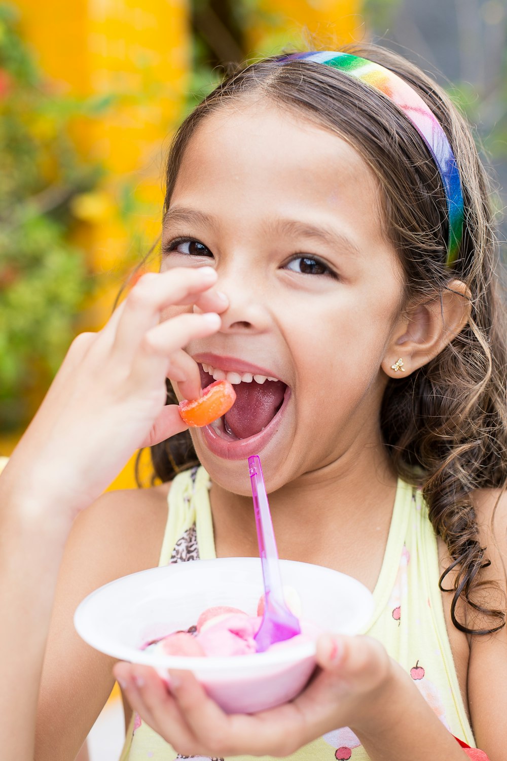 girl holding candy while putting to her mouth