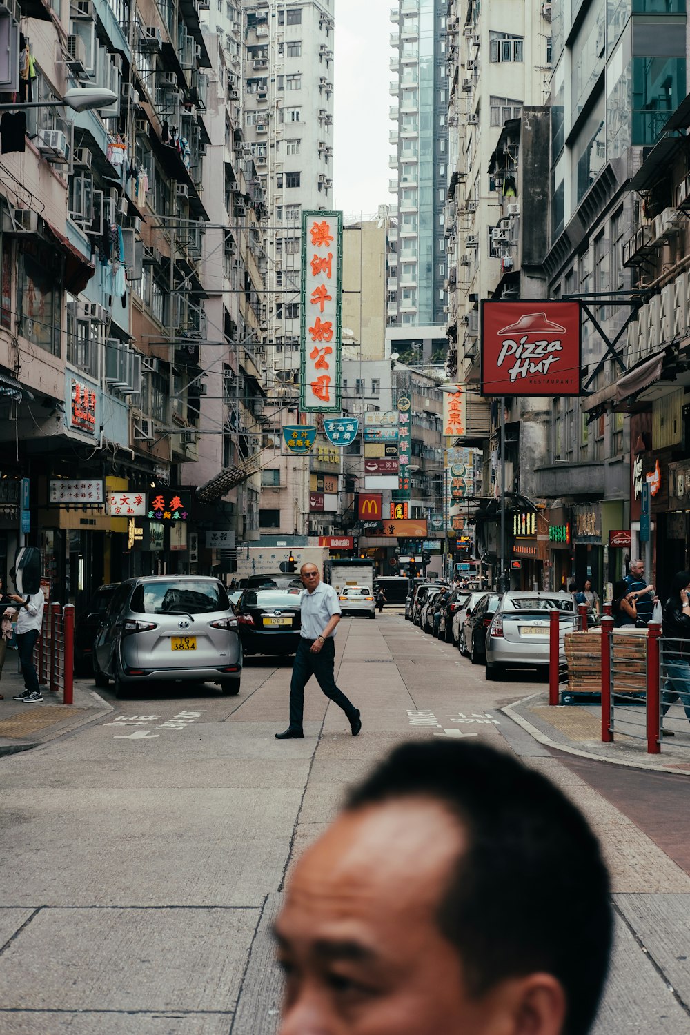 Ein Mann, der eine Straße neben hohen Gebäuden entlanggeht