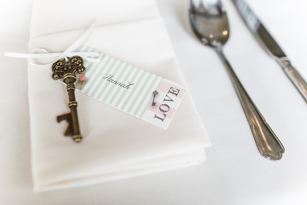 silver skeleton key on white textile