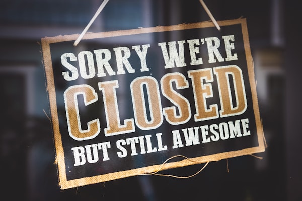 Sign Stating "Sorry we're closed but still awesome" (Photo by Tim Mossholder / Unsplash)