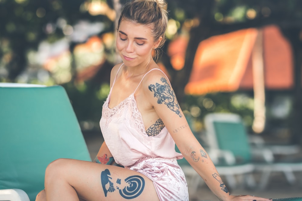 woman with tattoos sitting on lounge chair